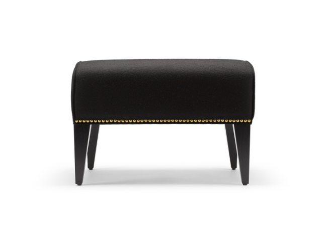 Black upholstered bench with gold nailhead trim and four tapered legs.
