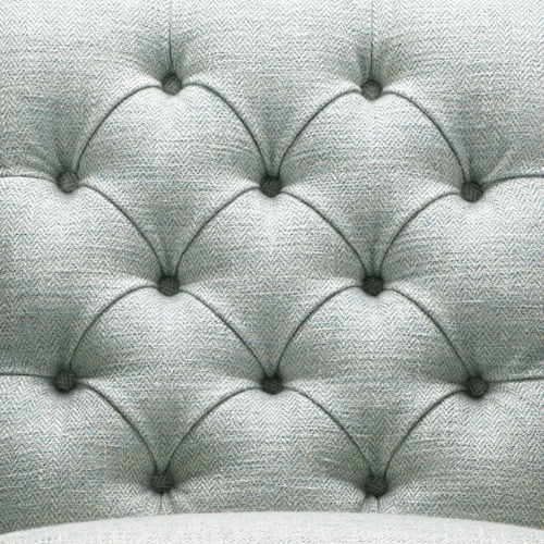 Close-up of a tufted, upholstered headboard or piece of furniture with button detailing in fabric.