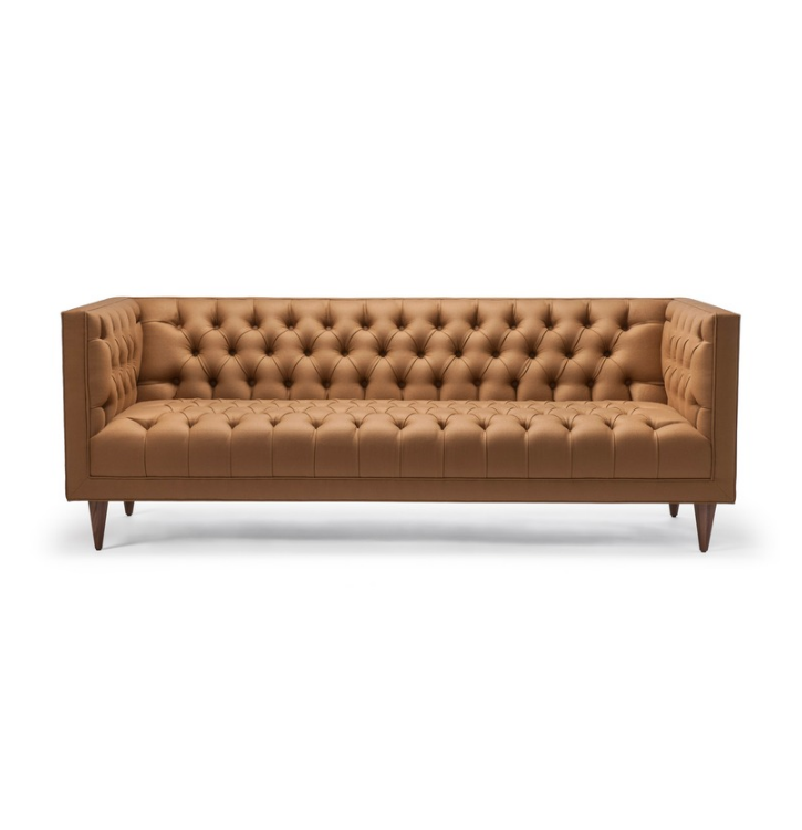 Brown mid-century modern tufted sofa with wooden legs against a white background.