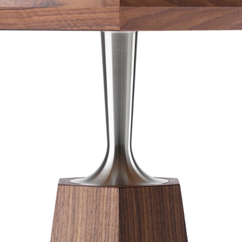Close-up of a wooden table with a metal pedestal leg and a wooden base.