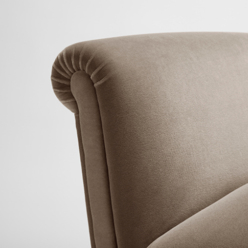 Close-up of a beige upholstered armchair with rounded armrest and smooth fabric.