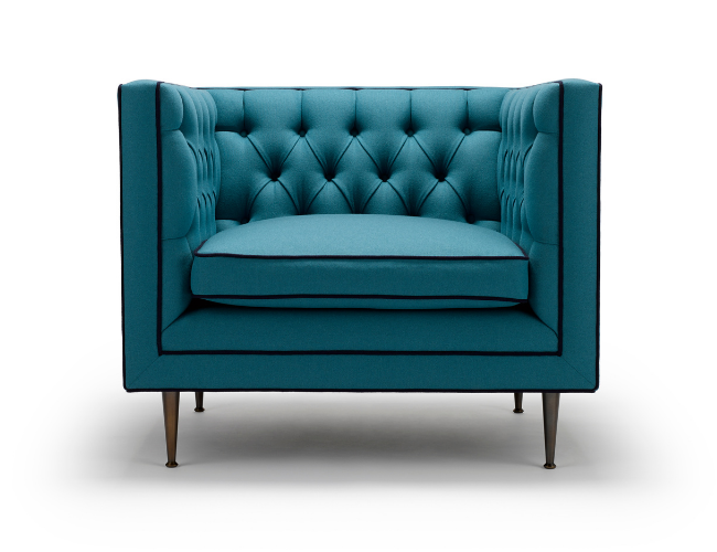 A modern teal upholstered armchair with tufted backrest and dark wooden legs