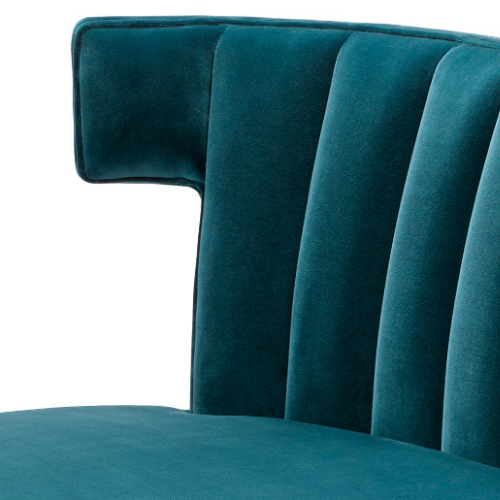 Close-up of a teal velvet upholstered chair with a high back and vertical stitching.