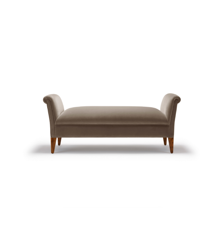 A beige upholstered bench with rolled arms and wooden legs on a white background.