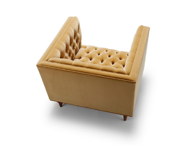 Beige tufted armchair with wooden legs.