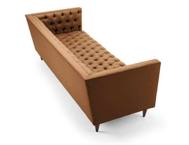 A brown upholstered chaise lounge with a tufted seat and backrest, angled armrest, and four tapered legs.