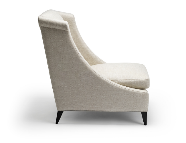 A beige upholstered armchair with a high backrest and black tapered wooden legs, viewed from the side against a white background.