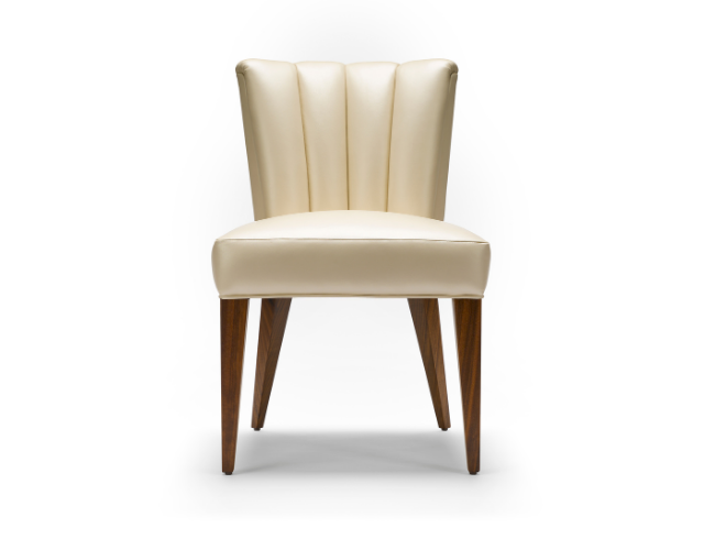 Cream-colored upholstered chair with curved back and wooden legs.