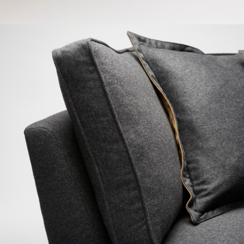 Close-up of a dark gray fabric sofa with a cushion.
