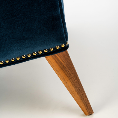 The Alae Lounge by Stuart Scott Furniture. Close up showing the decorative nailing and foot on the chair.