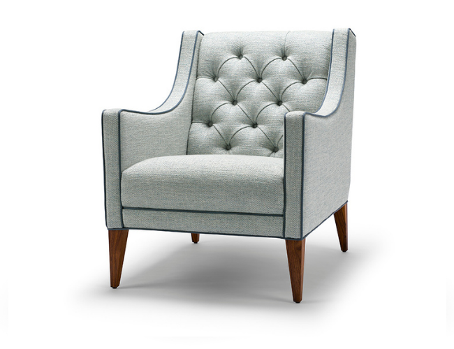 Gray upholstered armchair with button tufting on the backrest and wooden tapered legs.