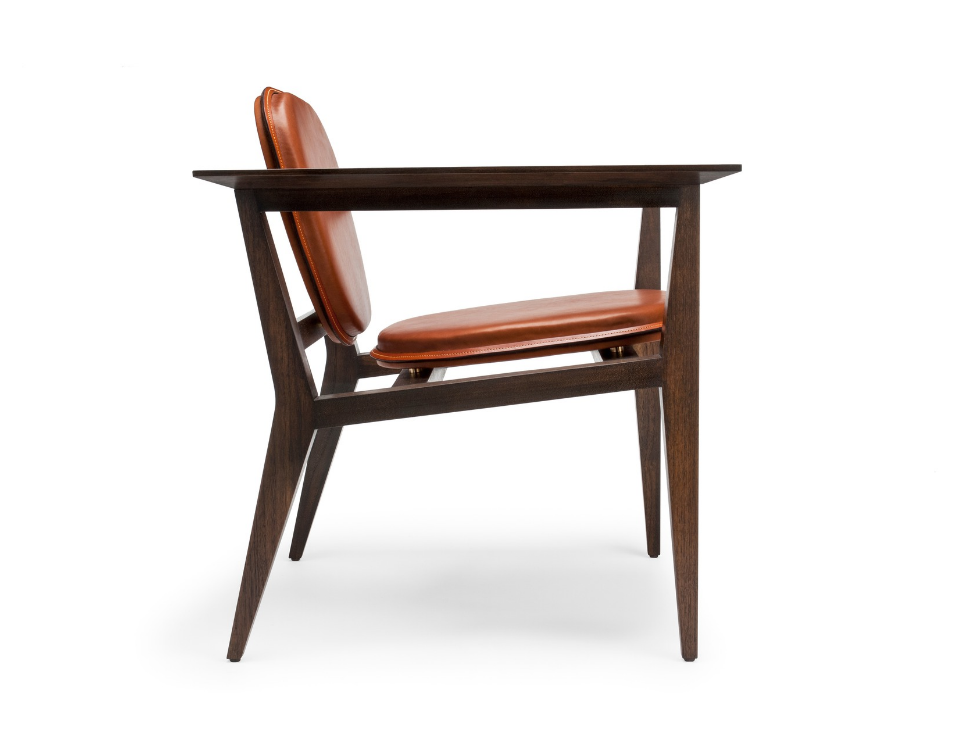 Side view of a wooden desk with a brown leather cushioned chair against a white background.
