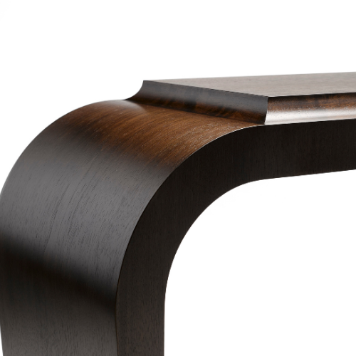 Close-up of a modern wooden table with a curved leg and a flat top surface.