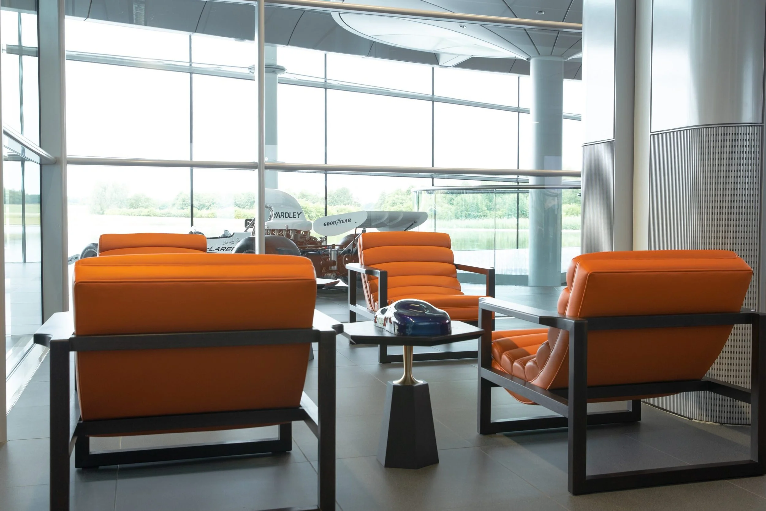 Stuart Scott Furniture's collaboration with McLaren extended to its Technology Centre, featuring hot orange leather covered Florence Easy Chairs and Black Lacquered Walnut Hex Side Tables