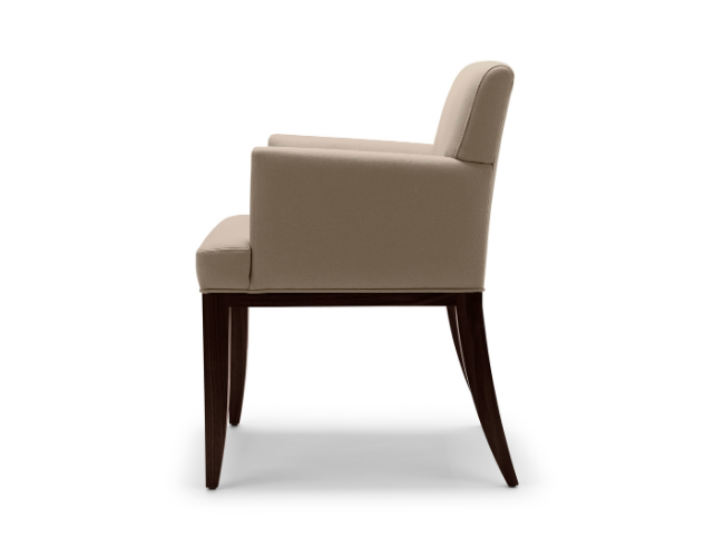 A beige upholstered armchair with wooden legs viewed from the side.