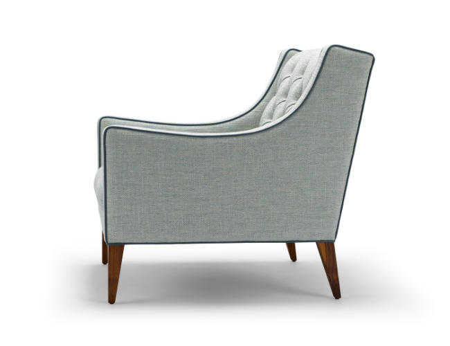 Side view of a mid-century modern upholstered armchair with gray fabric and wooden legs.