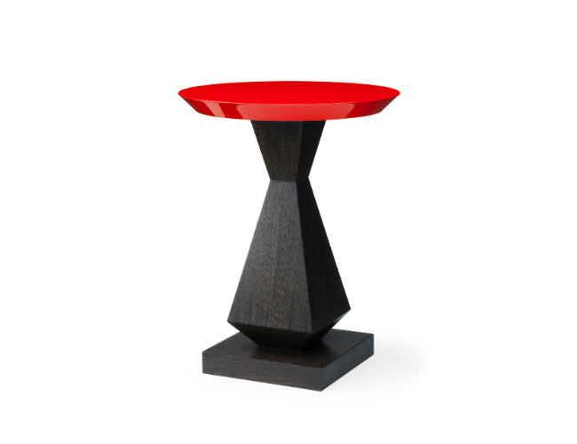 Modern side table with a geometric black base and a red circular top