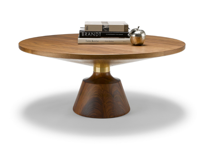 Round wooden table with three books and a decorative metallic object on top