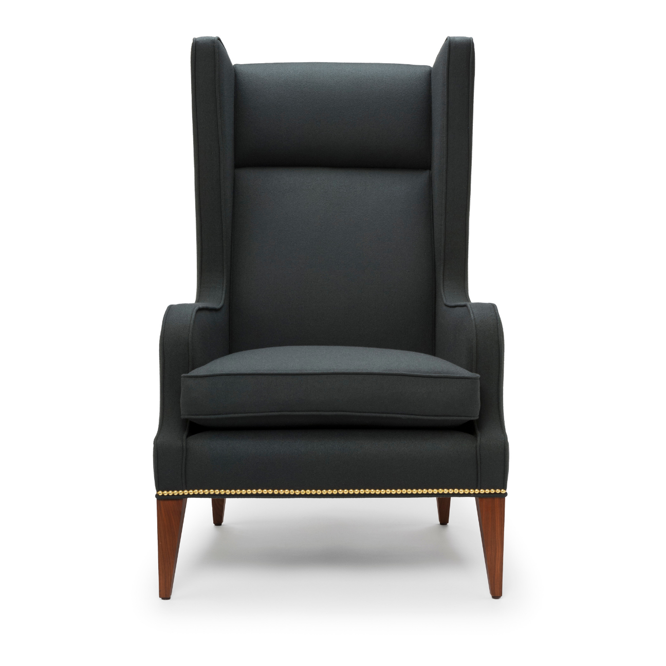 A high-back, dark gray armchair with wooden legs and nailhead trim along the bottom edge.