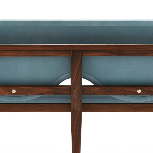 Close-up of a mid-century modern style bed frame with light blue upholstered headboard and side panels, and wooden support beams and legs.