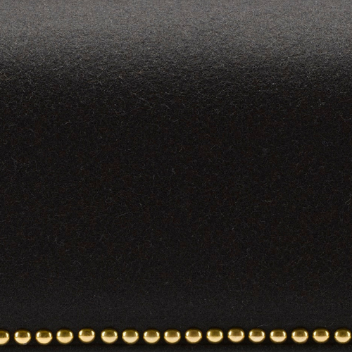 Close-up of a black surface with a row of small gold beads at the bottom.