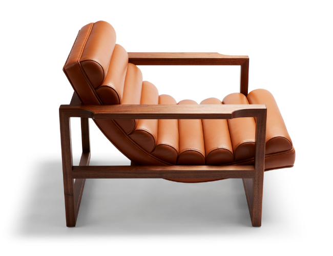 The Florence Easy Chair is a bare-wood constructed chair with a fluted leather seat in a light tan. Shown here from the side.