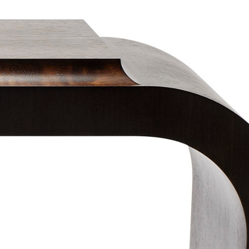 Close-up of a modern metallic table edge with a curved design, showing a brushed metal surface and a dark underside.