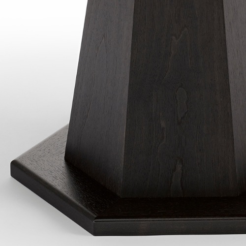 Close-up of a dark wooden table or stand with a hexagonal shape and a smooth, polished surface.