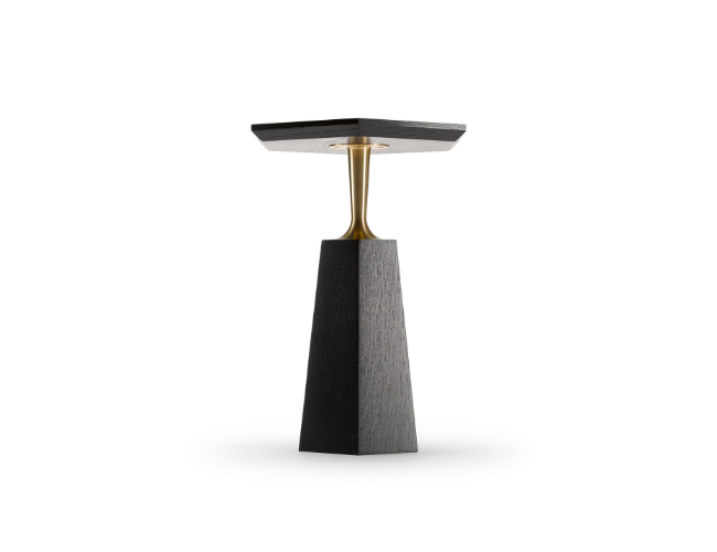 A modern side table with a black textured base, a gold-colored stem, and a square black top.