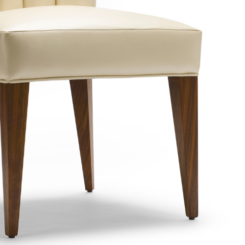 Close-up of a modern beige upholstered stool or chair with wooden legs on a white background.