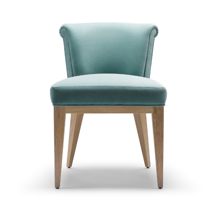 Mint green upholstered chair with wooden legs and a rounded backrest.