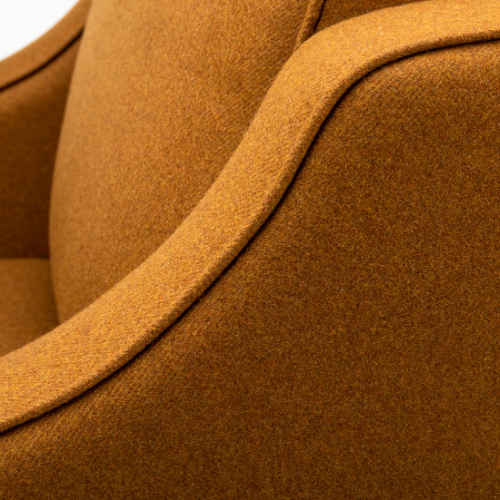 Close-up of a brown upholstered chair with curved armrest.