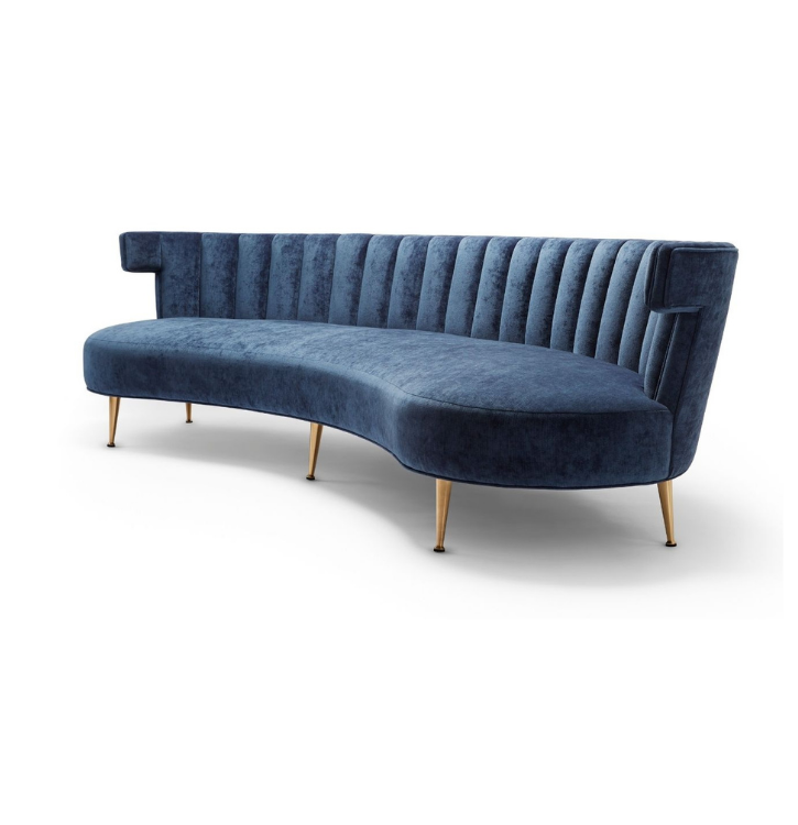 A modern, navy blue velvet sofa with curved design, vertical channel tufting on the backrest, and wooden tapered legs.