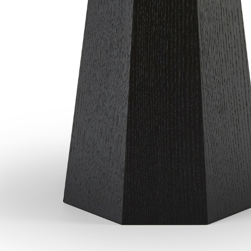 Close-up of a black, textured wooden furniture leg or base with a geometric shape.