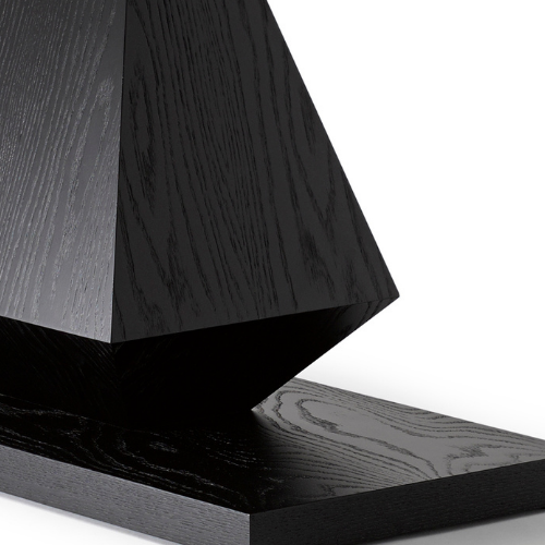Close-up of a black wooden geometric sculpture with sharp angles.