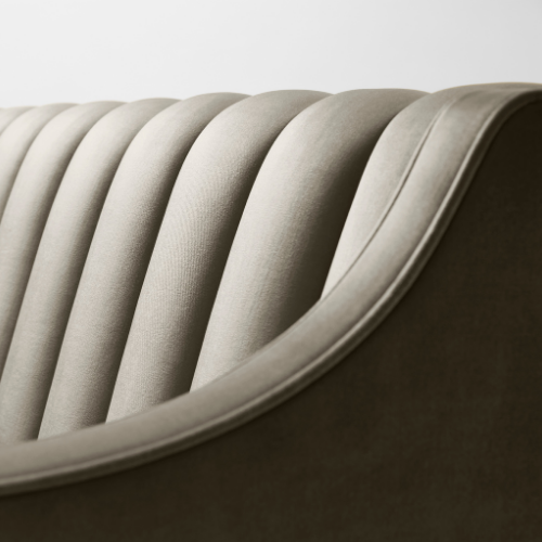 Close-up of a modern beige upholstered chair with curved backrest and vertical padding.