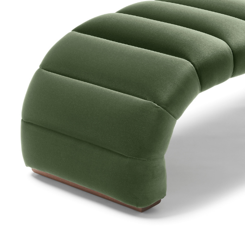 Close-up of a green upholstered curved chair or sofa with segmented cushions.