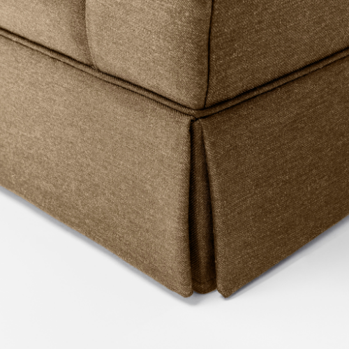 Close-up of a corner of a brown upholstered sofa showing the fabric and seam details.