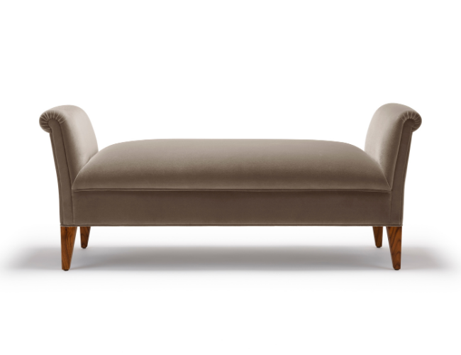 Beige upholstered bench with curved armrests and wooden legs on a white background.