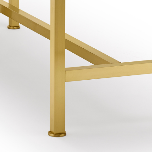 Close-up of a gold-colored metal table leg and frame against a white background.
