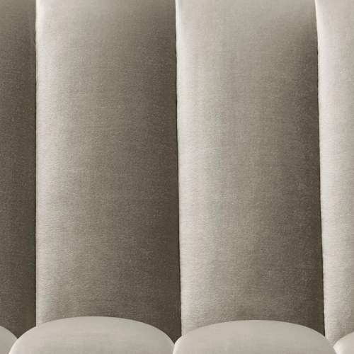 Close-up of a row of padded fabric chairs in a waiting area.