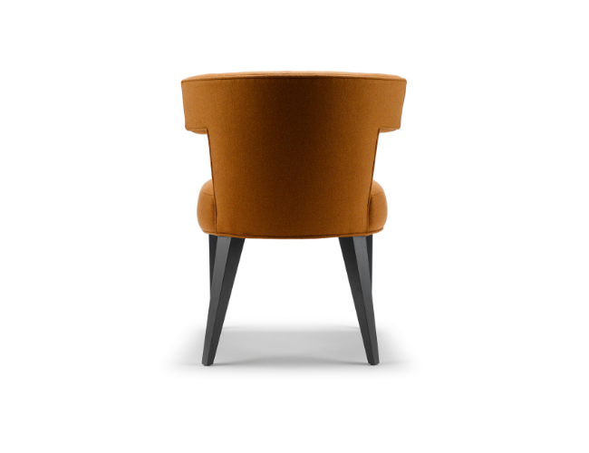 Orange upholstered armchair with dark wooden legs, facing away against a plain white background.