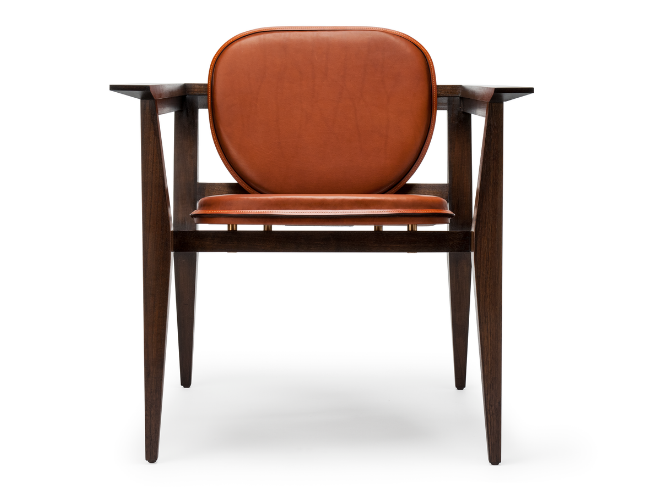 Mid-century modern armchair with dark wooden frame and orange leather upholstered seat and backrest, isolated on white background.