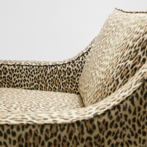 Close up of The Reposer Chair, showing the seat with leopard print fabric