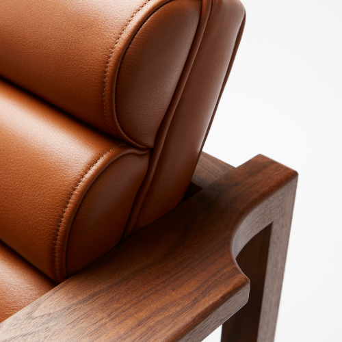 The Florence Easy Chair is a bare-wood constructed chair with a fluted leather seat in a light tan. The back corner of the arm and flute shown here