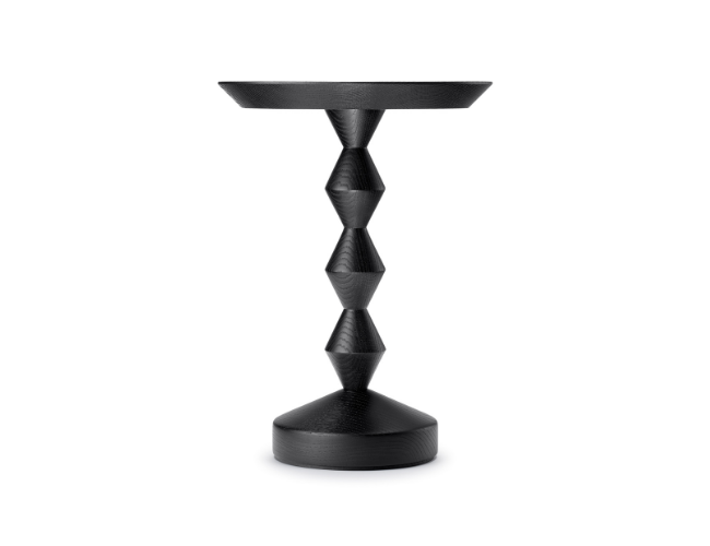 Black geometric side table with a round top and a tiered, angular base.