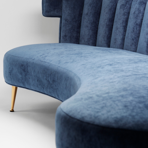 Close-up of a blue velvet sofa with gold legs against a white background.