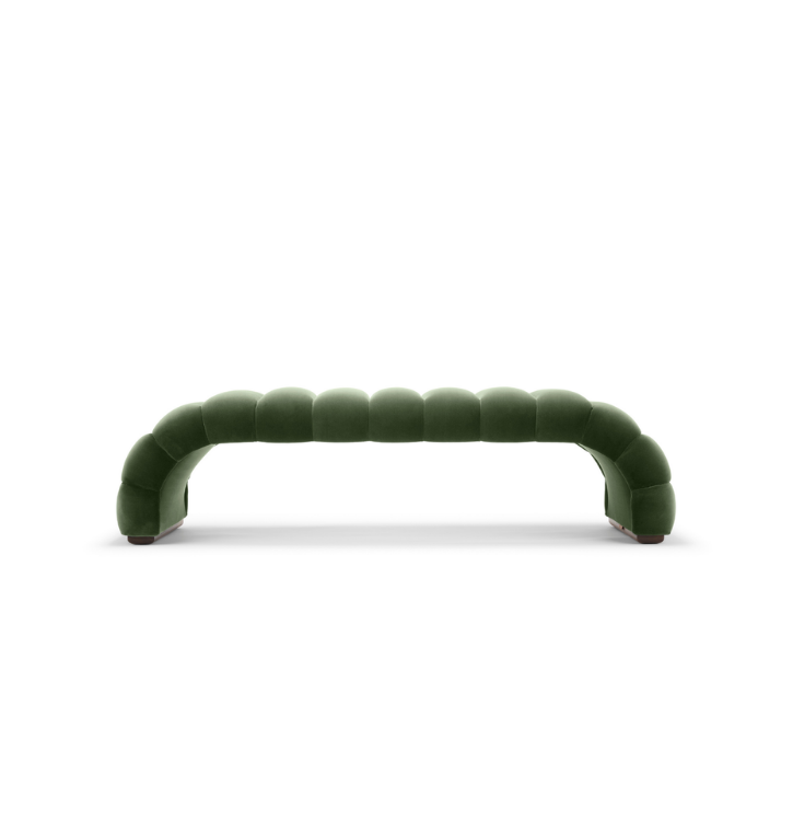 A modern green sofa with curved, segmented design against a white background.