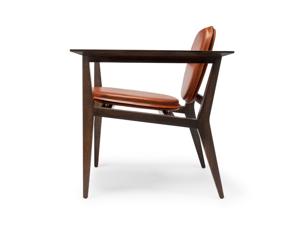 Side view of a wooden desk with a leather-upholstered chair against a white background.