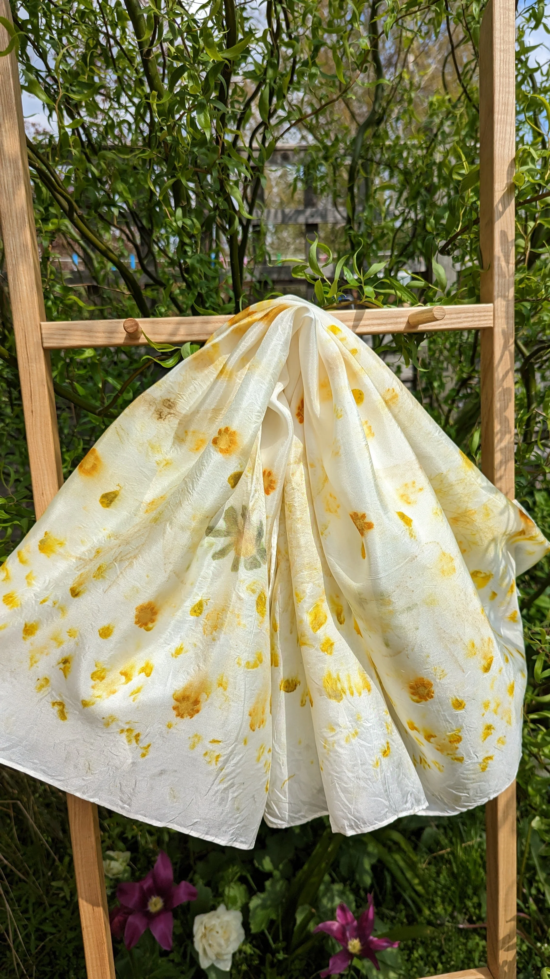 Steamed yellow flower silk scarf hung on display ladder.jpg